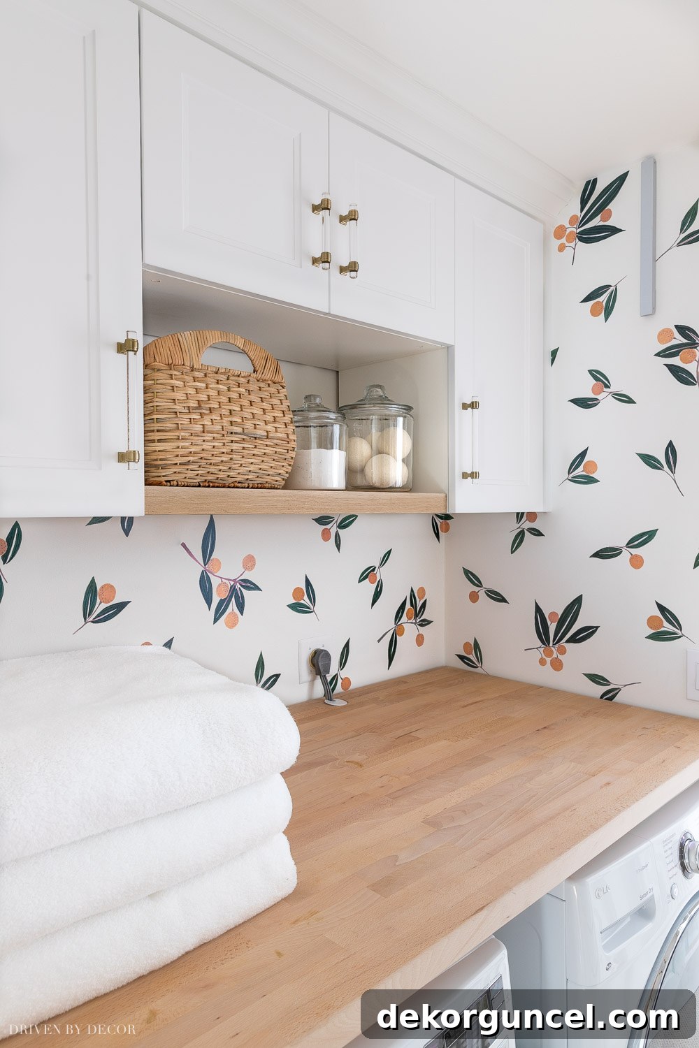 IKEA Sektion cabinet frames and Axstad doors installed above the laundry room washer and dryer, offering stylish and functional storage solutions.