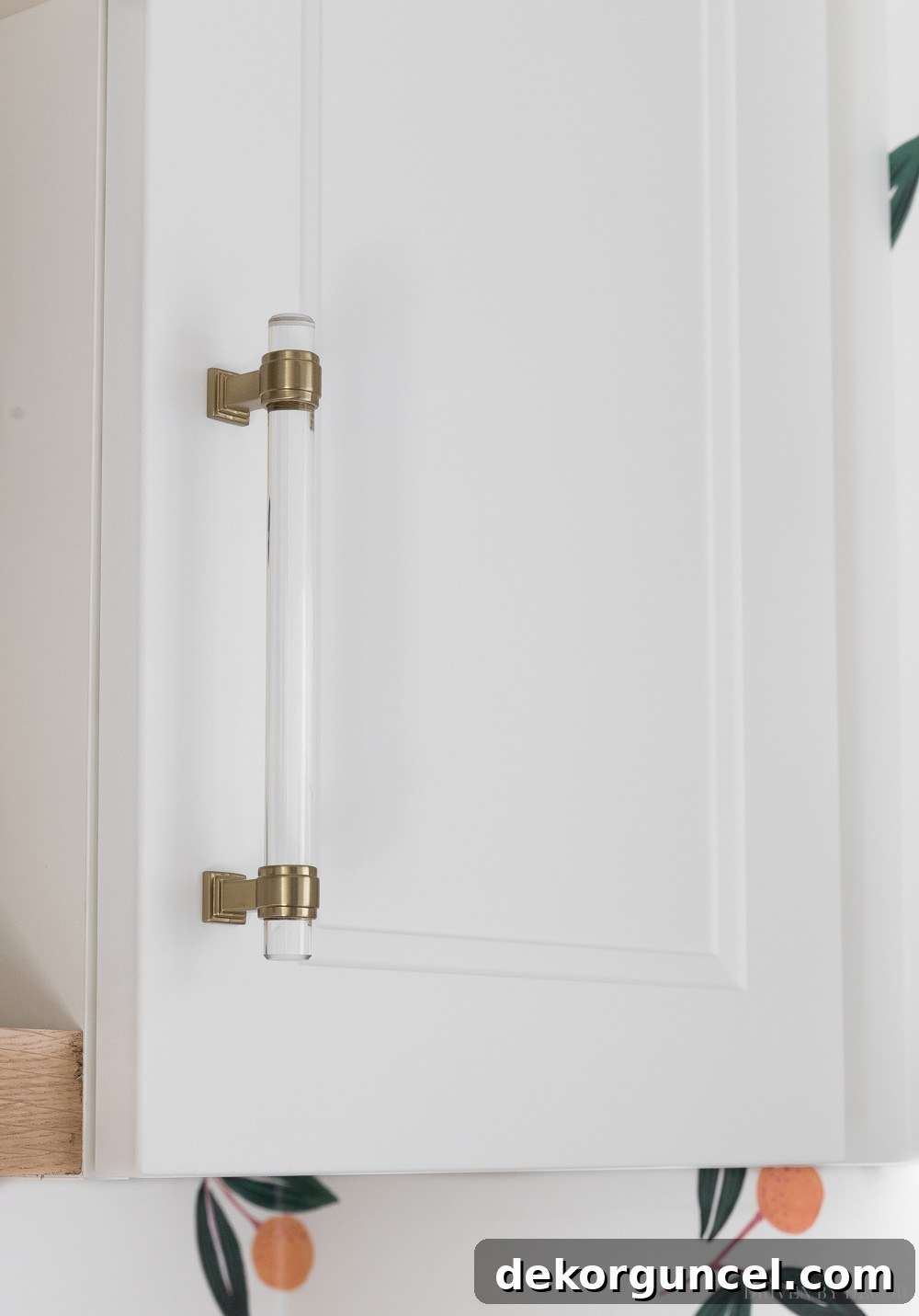 Close-up of acrylic cabinet pulls in Golden Champagne finish on IKEA laundry room cabinets, highlighting the stylish hardware.