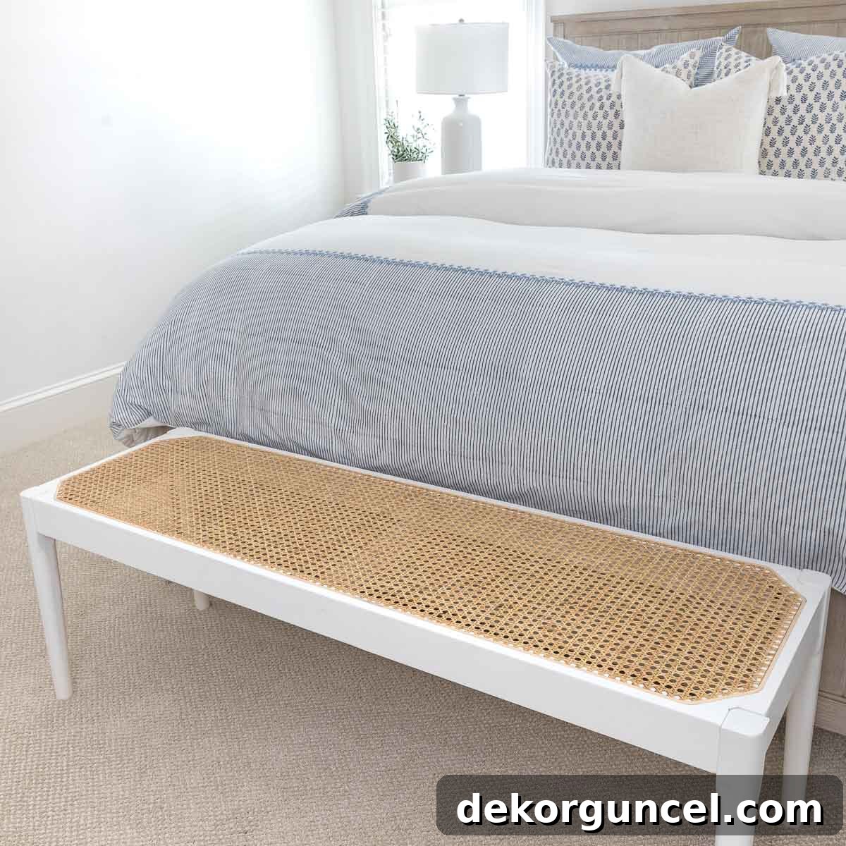 Coastal bedroom decor featuring a stylish cane bench at the foot of the bed