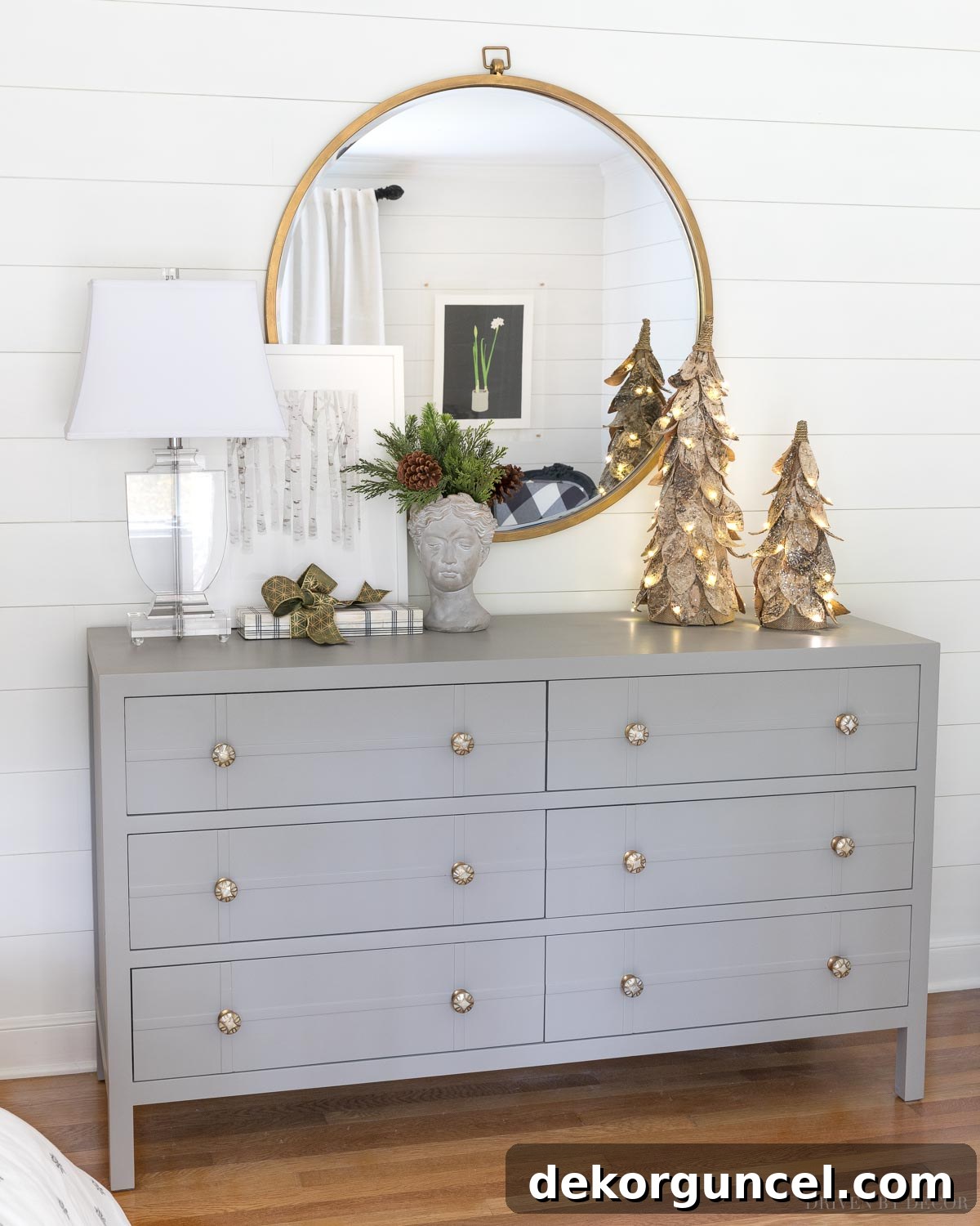 Elegant Christmas decor in our bedroom, featuring lush faux greenery in a unique bust planter and charming pre-lit birch Christmas trees for a serene holiday ambiance.