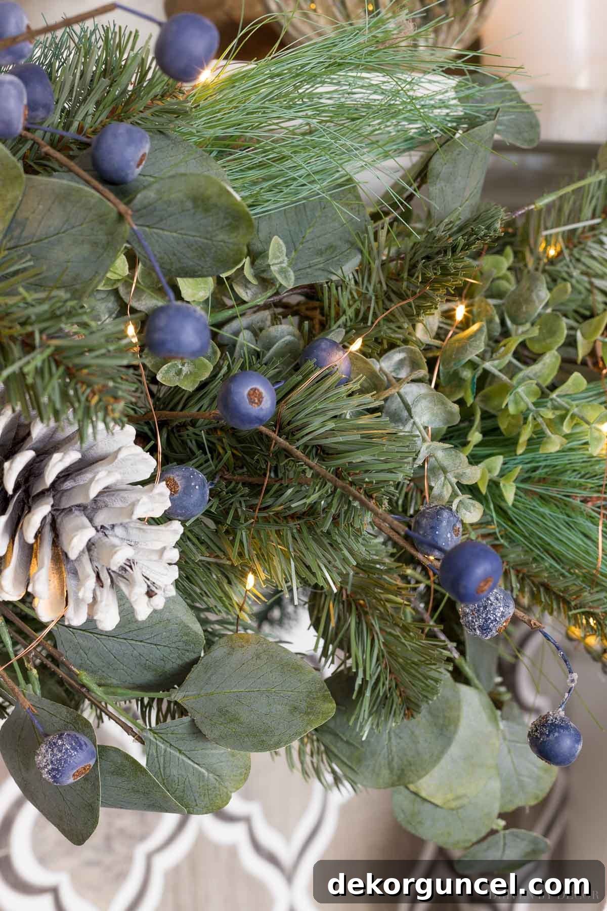 Detailed view of our Christmas garland, showcasing the realistic combination of faux pine, eucalyptus, frosted berries, and rustic pinecones arranged on the mantel.