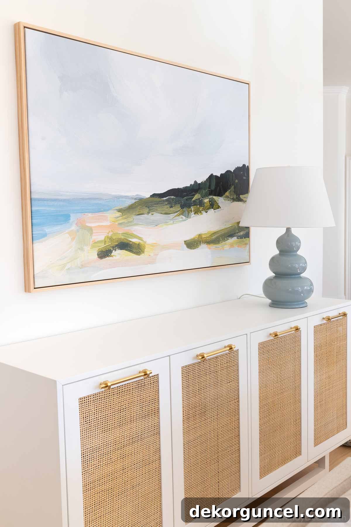 Cane sideboard, large canvas art print, and elegant blue gourd lamp in a beautifully styled dining room