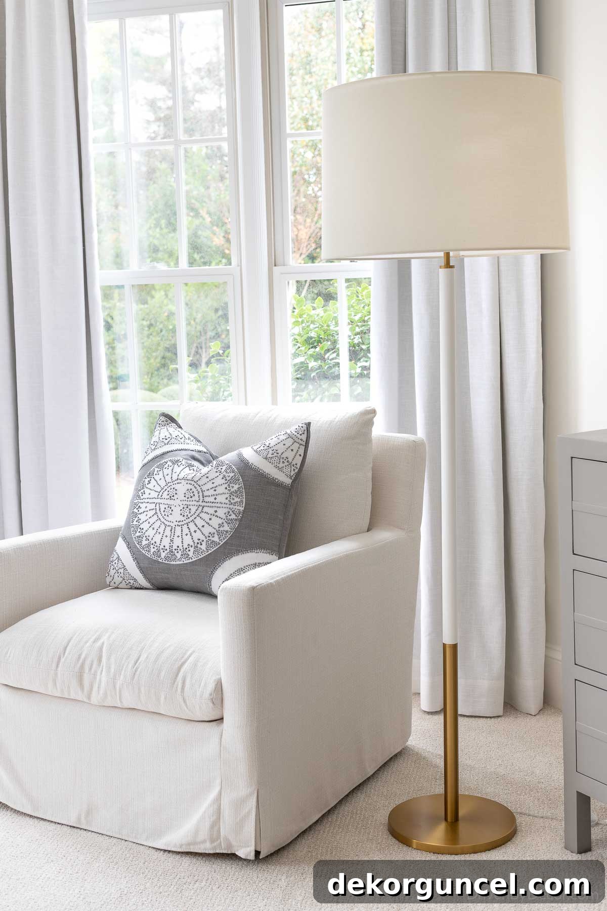 Sophisticated brass & white bedroom lamp positioned next to a comfortable reading chair, perfect for a cozy nook