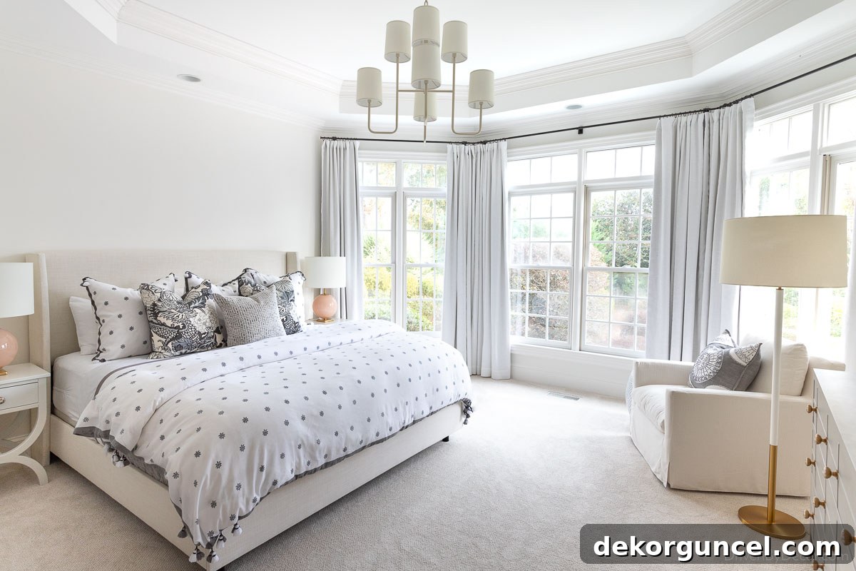 Primary bedroom after transformation, featuring elegant bedside lamps, a floor lamp by a reading chair, and a chandelier with shades, creating a harmonious and inviting space