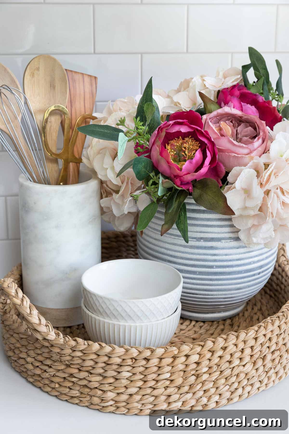 The Most Realistic Faux Flowers 2 A stunning arrangement of Afloral's realistic artificial flowers, including English cabbage roses, blush hydrangeas, seeded eucalyptus, and fuschsia peonies, displayed in a woven tray in a stylish kitchen setting, adding vibrant life to the space.