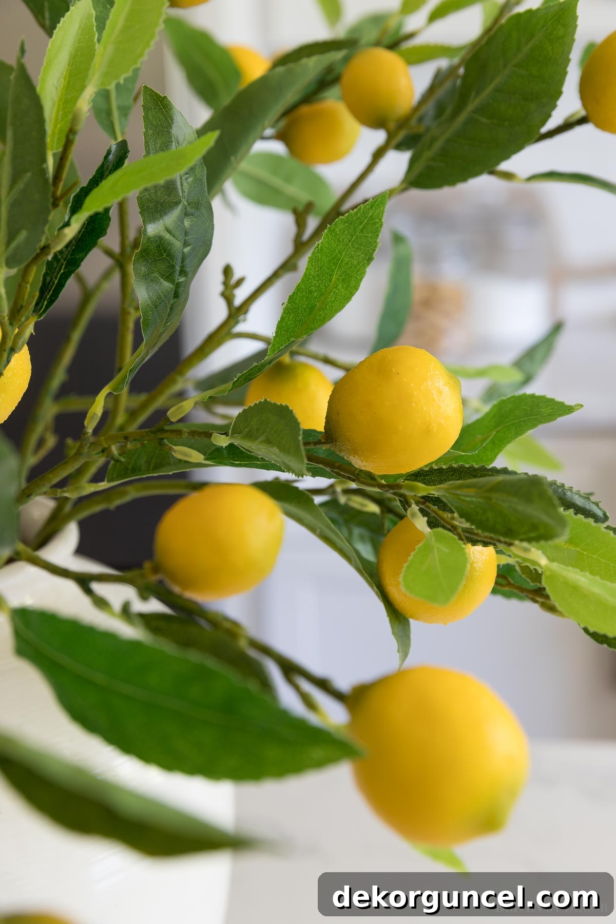 The Most Realistic Faux Flowers 20 Detailed close-up of exceptionally realistic artificial lemon branches, highlighting their textured leaves and bright yellow lemons, meticulously arranged for a lifelike and cheerful floral display.