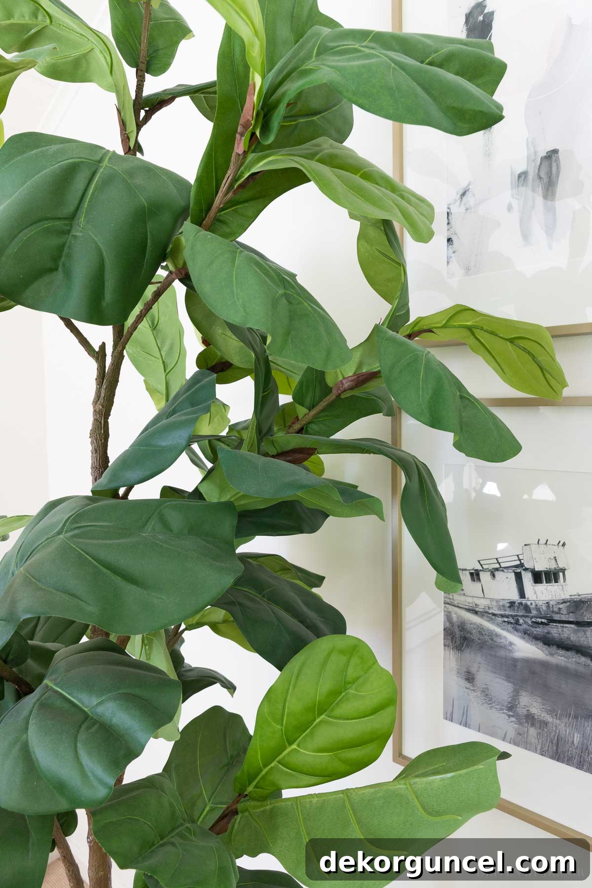The Most Realistic Faux Flowers 23 A detailed close-up of a highly realistic artificial fiddle leaf fig tree's leaves, showcasing their natural texture, intricate veining, and vibrant green color, highlighting the plant's authentic appearance.