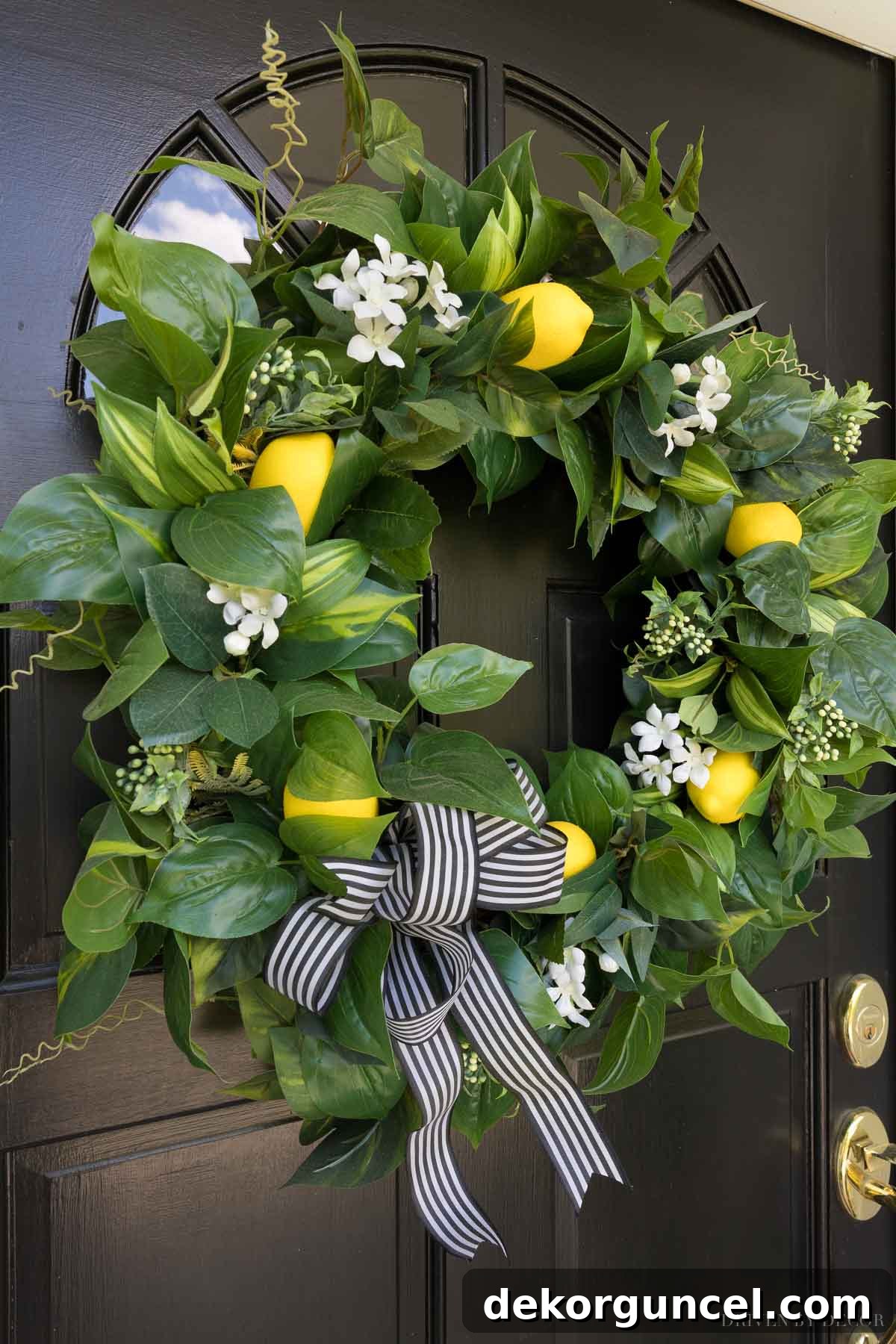The Most Realistic Faux Flowers 24 A beautiful spring wreath for a front door, featuring realistic artificial greenery, colorful flowers, and bright yellow lemons, adorned with a charming striped ribbon, creating a welcoming entryway.