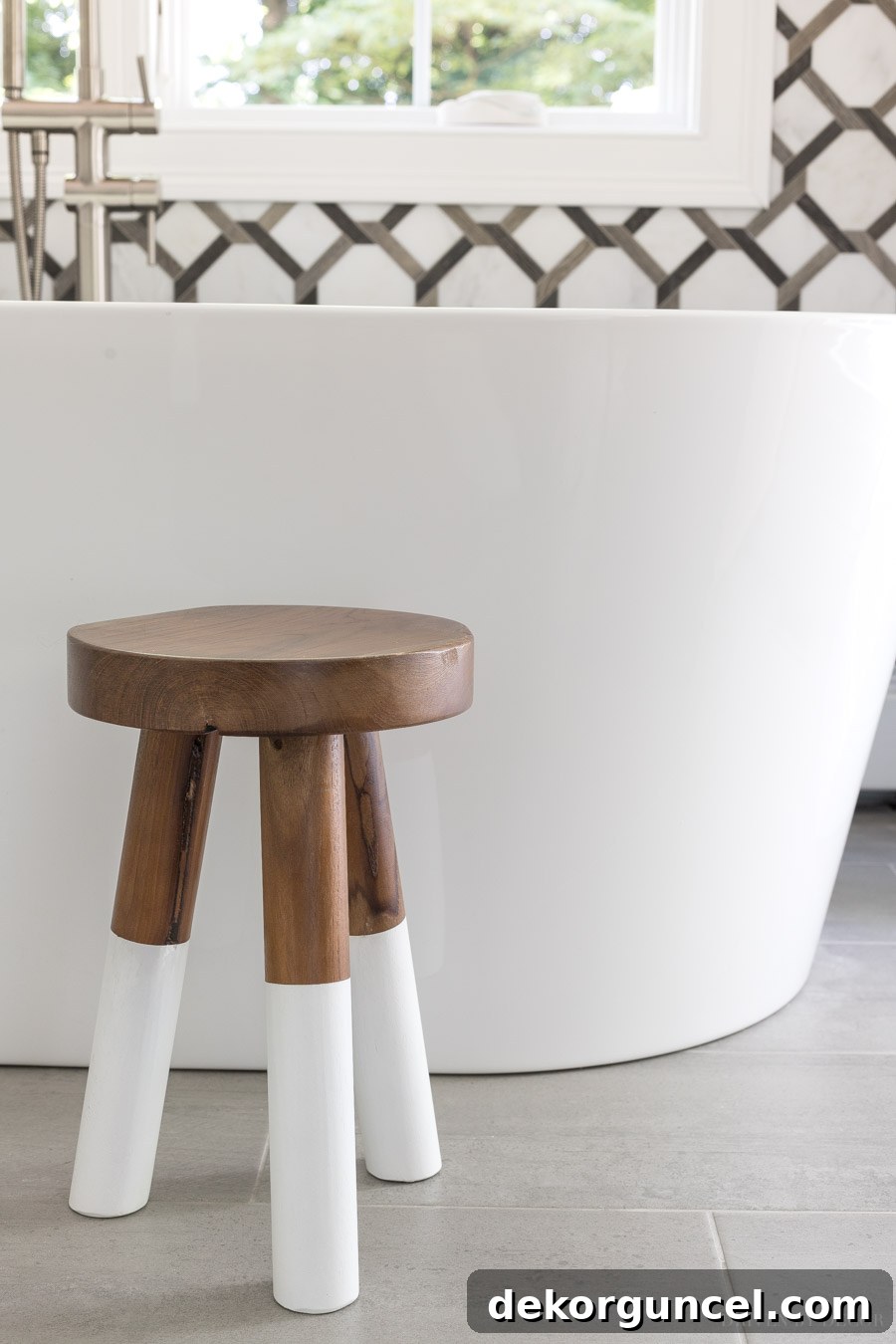 The cutest wood stool by the freestanding tub in this master bathroom