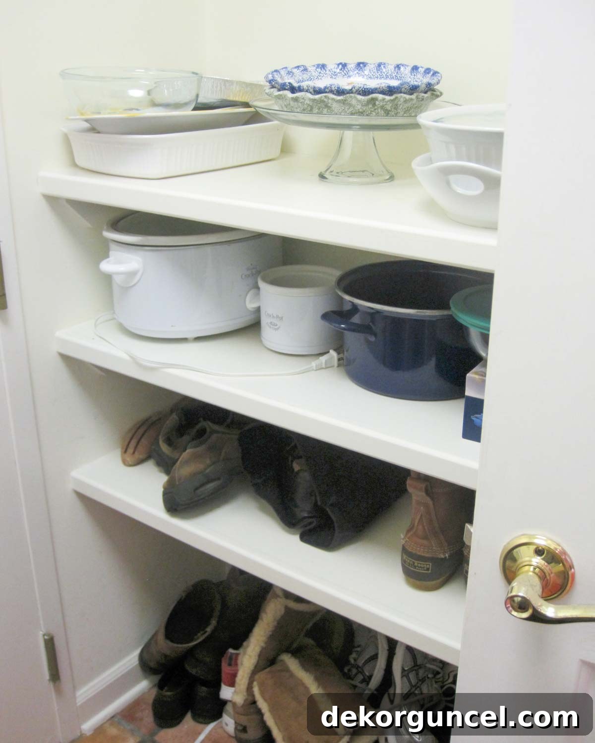 Laundry room before remodeling, showing a shallow nook with disorganized shelving