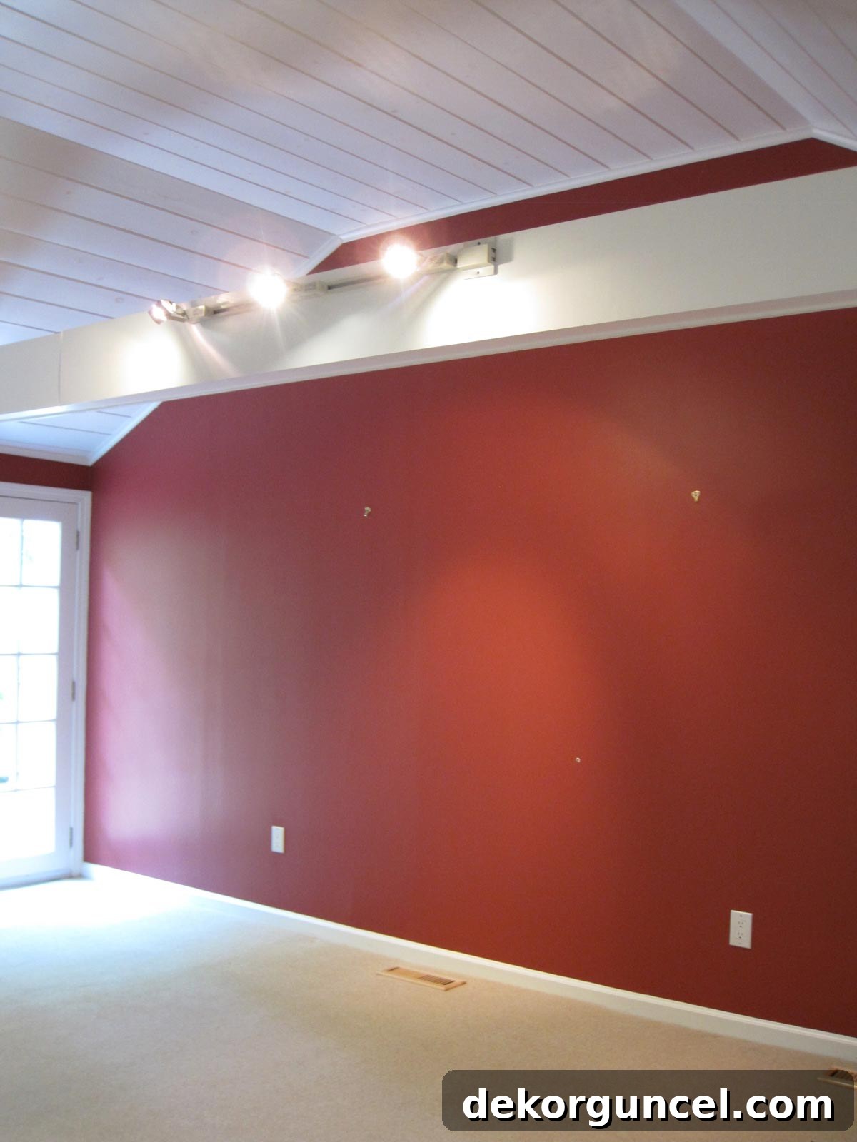 Family room before remodeling, showing dated track lighting mounted on beams