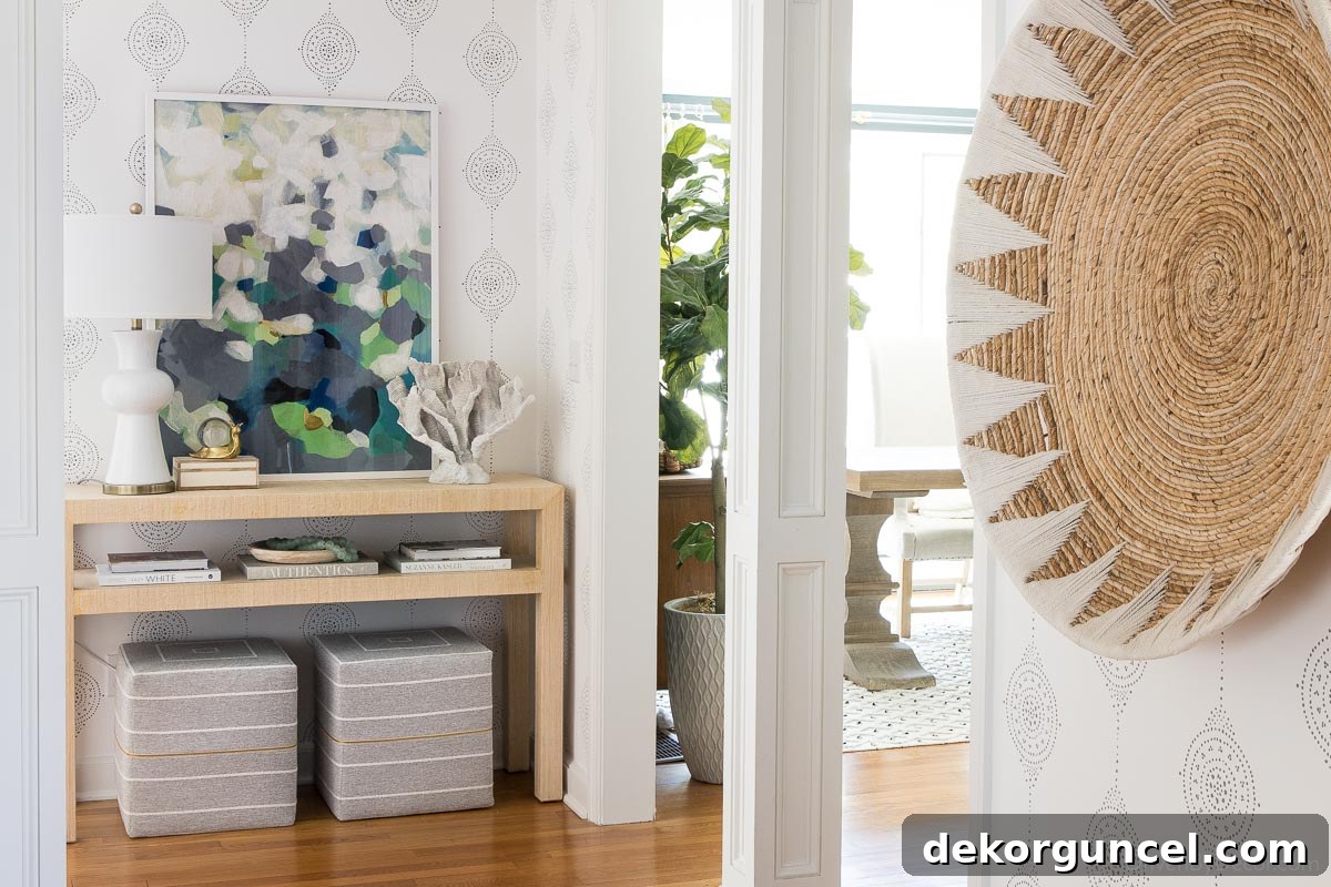 Transformed entryway with striking wallpaper, rug, and updated lighting, creating a welcoming atmosphere