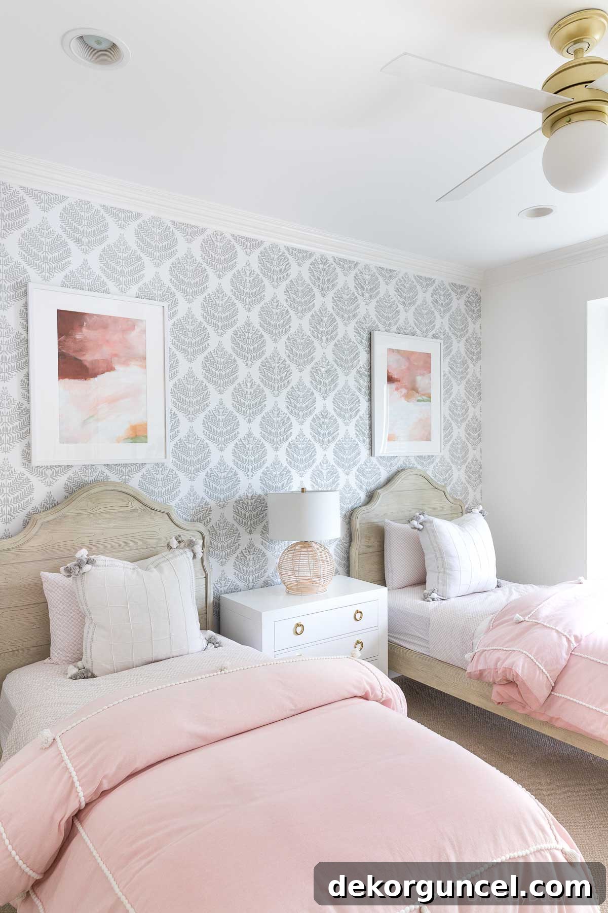 Two framed art prints individually hung above twin beds, perfectly scaled for a child's room decor.