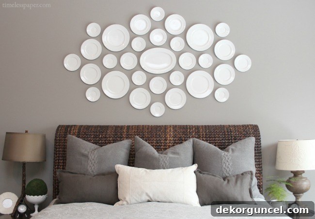 Elegant collection of white decorative plates arranged above the bed, creating a sophisticated wall art display.