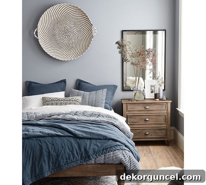 Statement woven basket from Pottery Barn as unique wall art over a bed.