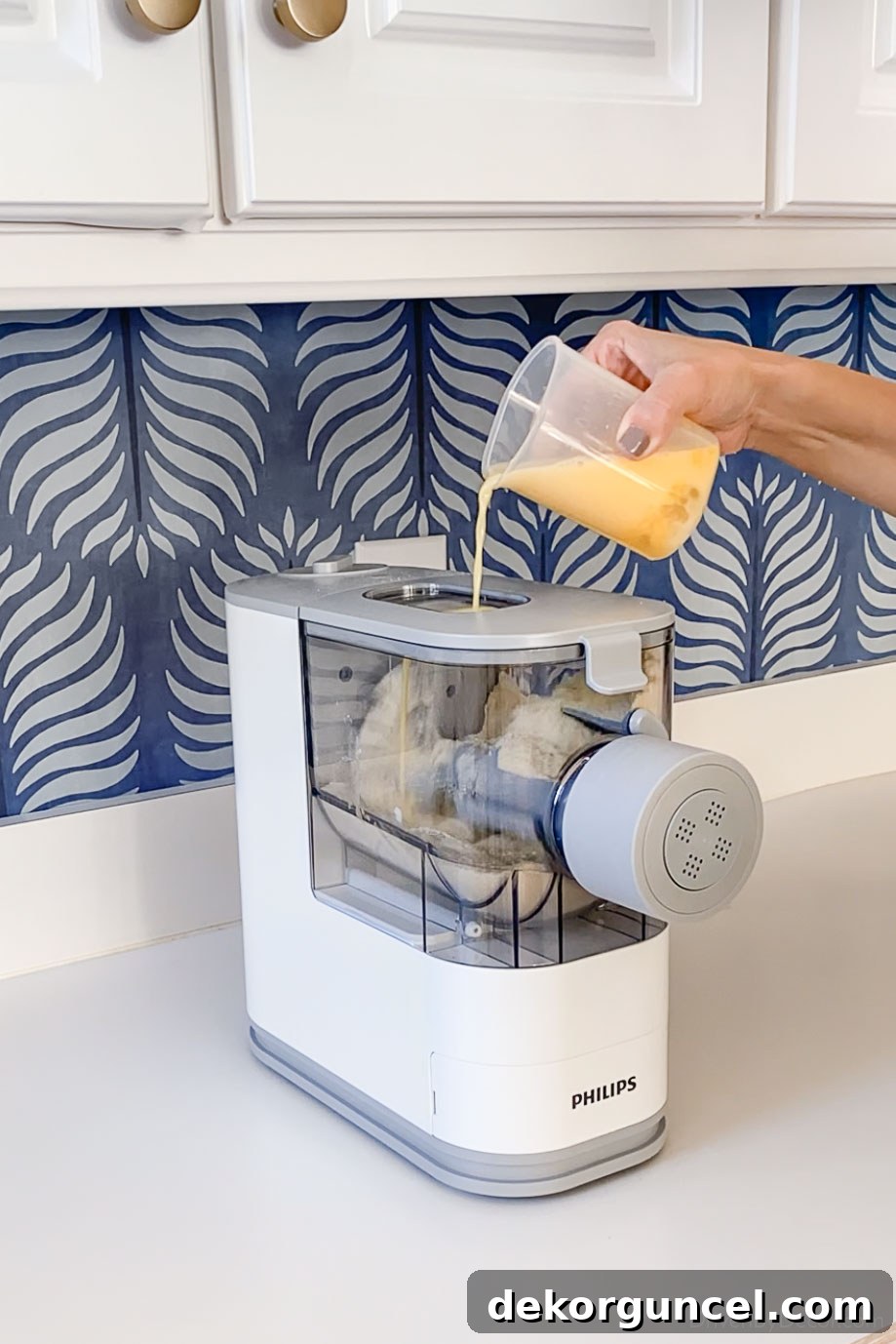5 Small Kitchen Game Changers And Where to Find Bargains 21 Adding liquid ingredients to the automatic pasta making machine for homemade noodles.