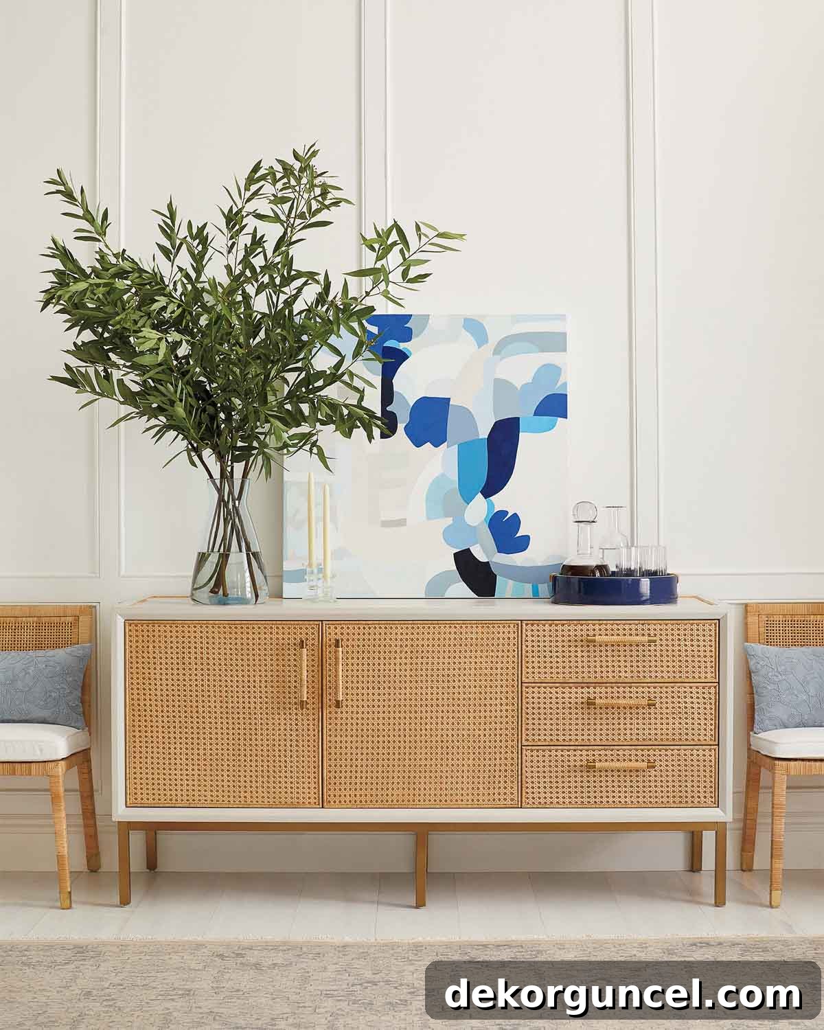 A beautifully styled sideboard featuring a piece of art, a vase with greenery, and barware, creating an elegant focal point for dining room wall decor.