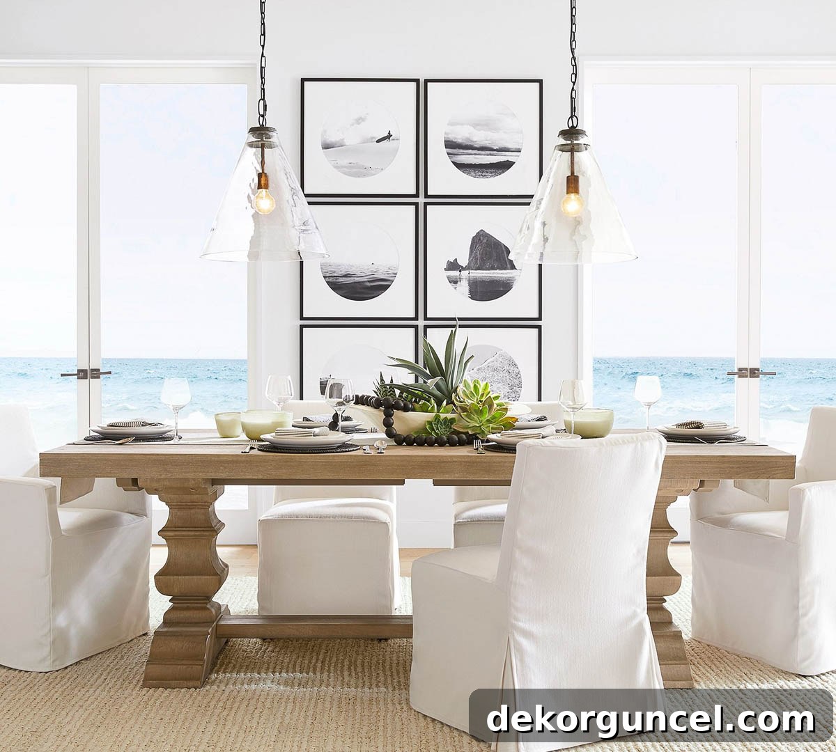 A light wood trestle dining table is complemented by a gallery wall featuring a series of framed art and photographs arranged in a perfect grid, creating engaging wall decor.
