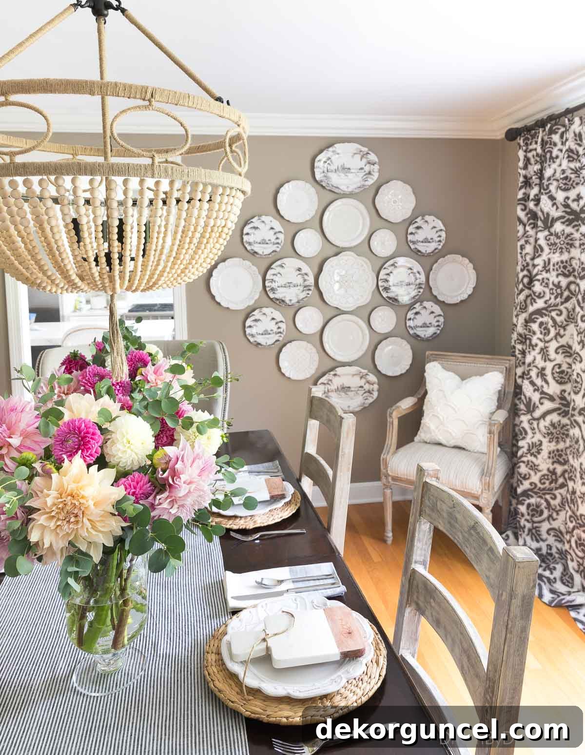 A stunning plate wall featuring mixed Juliska dinnerware and serving pieces, creating elegant wall decor in a dining room setting.