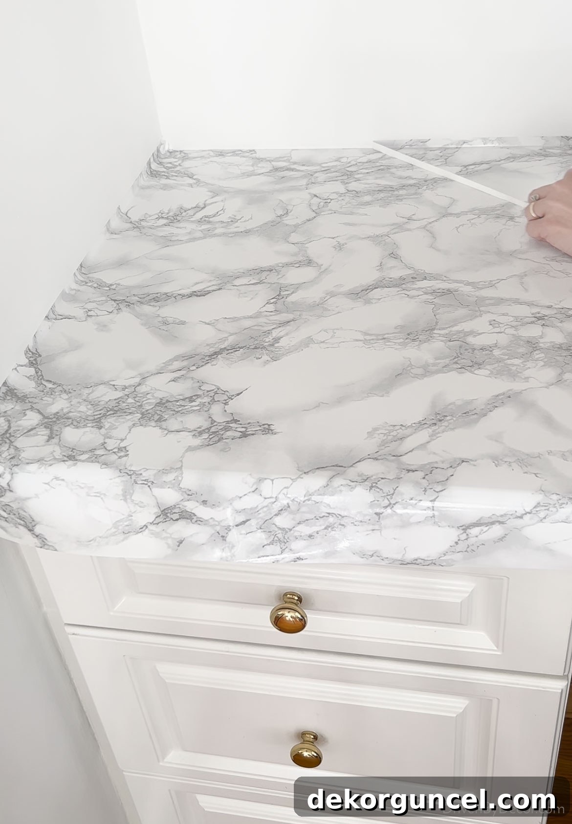 Removing excess marble contact paper after trimming the countertop edge