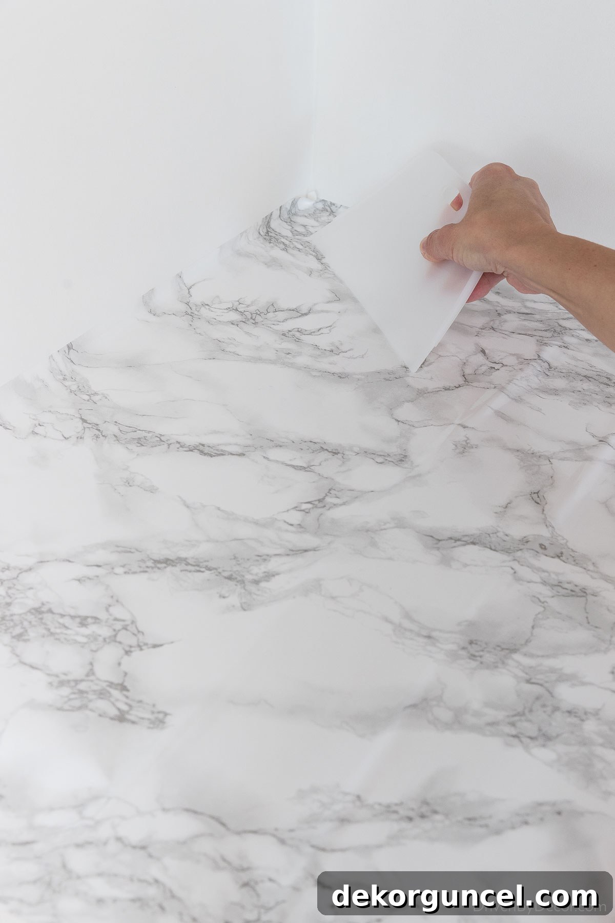 Smooth out the first section of contact paper, eliminating air bubbles