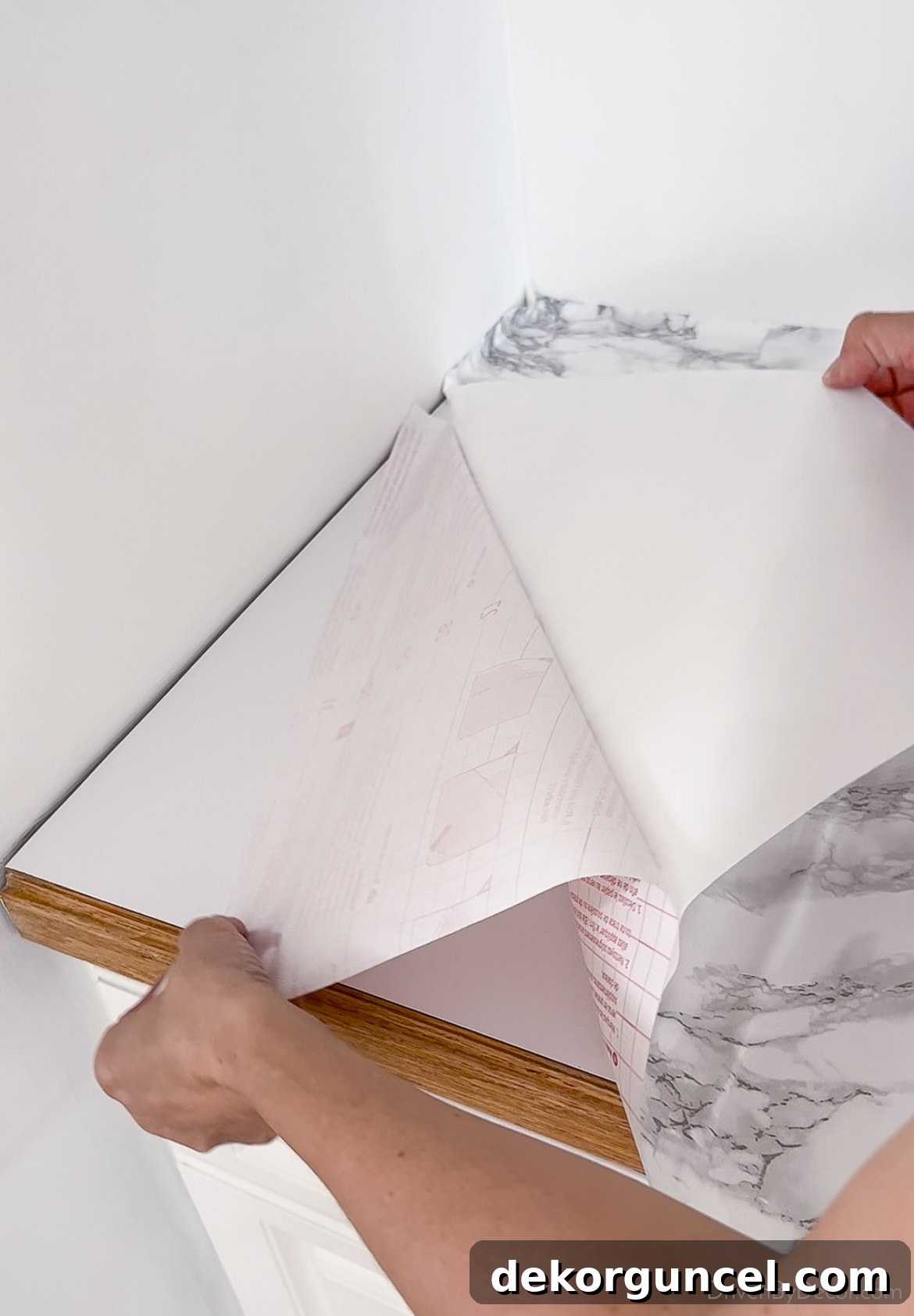 Gradually remove backing while adhering contact paper to countertops