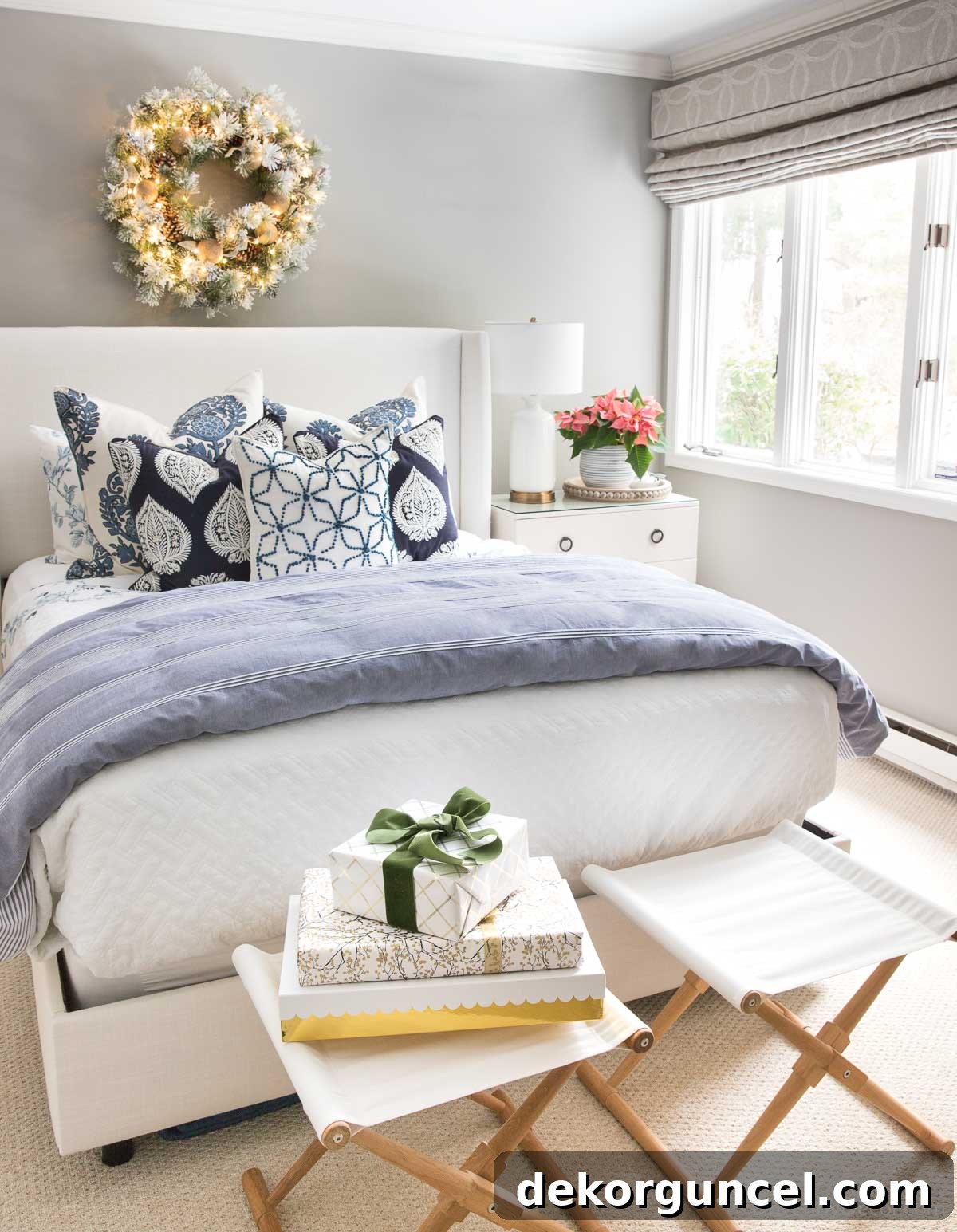A lighted Christmas wreath gracefully hung above a guest bed, adding simple holiday decor