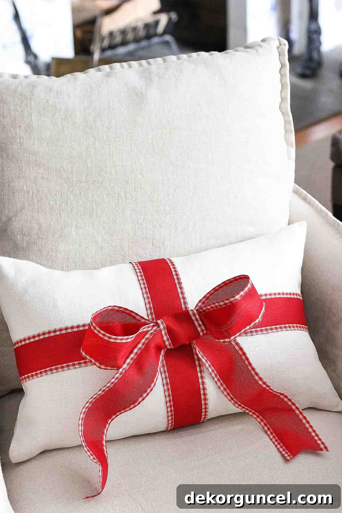 Plain pillow wrapped with a festive ribbon and tied in a bow, transforming it into a Christmas accent