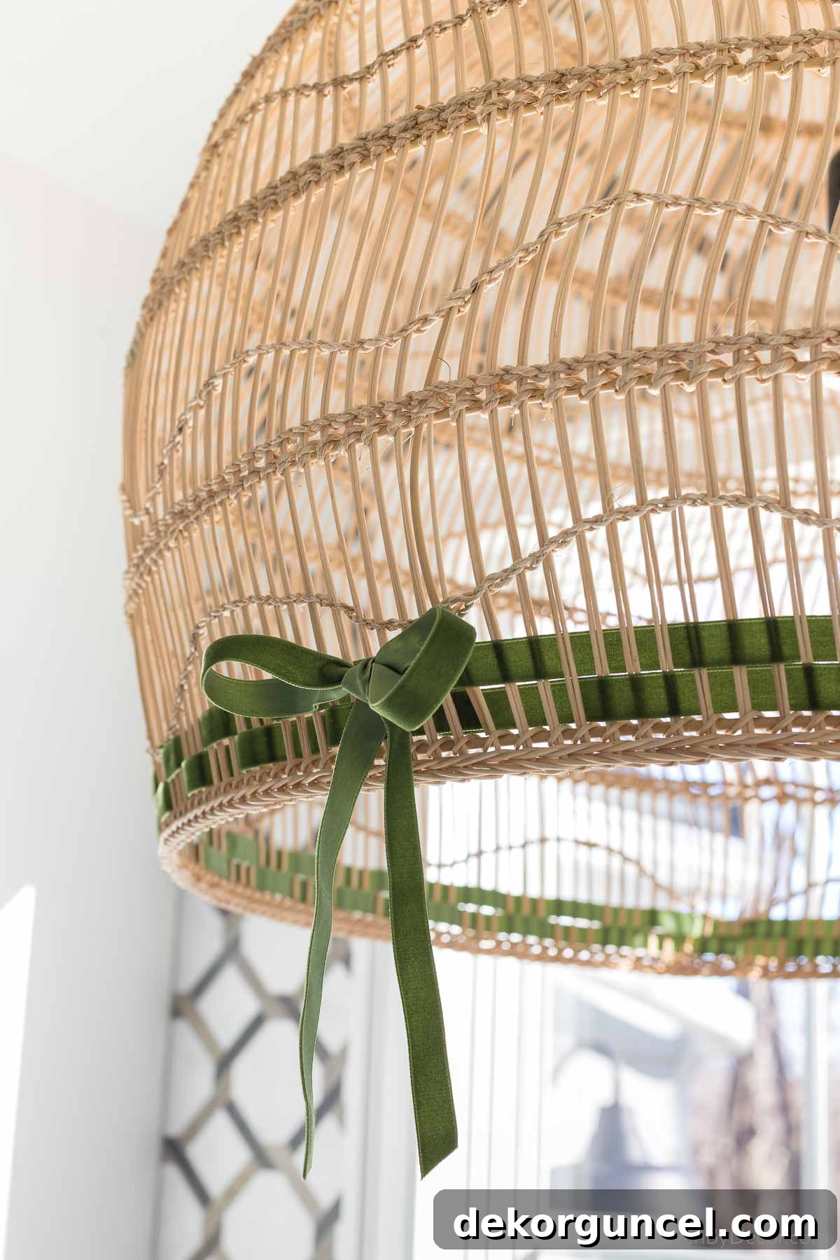 Green velvet ribbon woven into a large pendant light, adding a simple Christmas touch to a bathroom