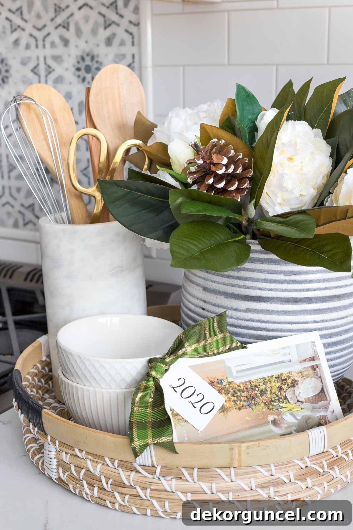 Holiday photo cards tied together with a bow and tag, displayed with faux magnolia branches and peonies