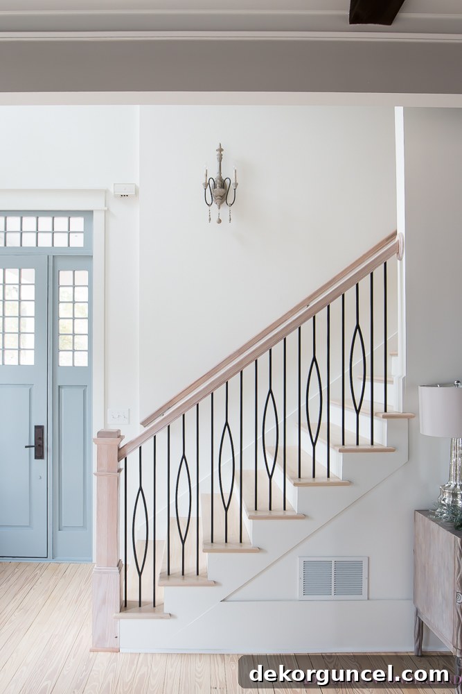 Stairway painted in Sherwin Williams' Alabaster (both walls and trim) - Brittany of Addison's Wonderland. This warm white beautifully enhances architectural details, creating a soft and inviting transition between floors.