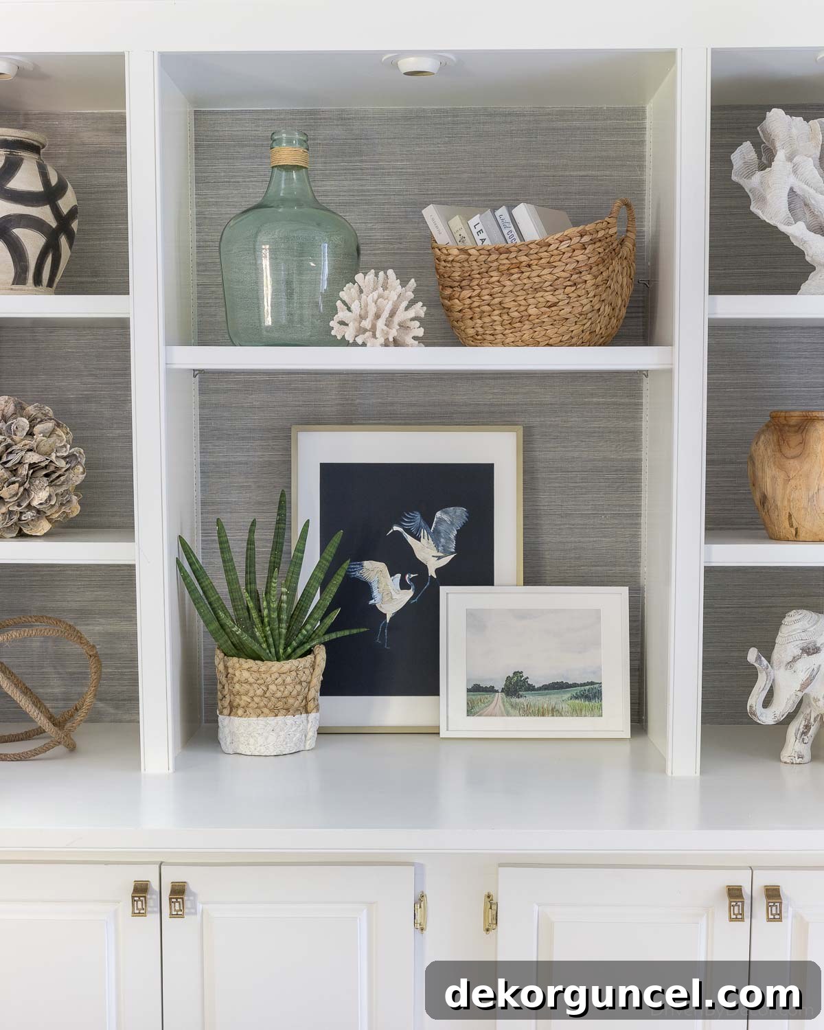 Charcoal grasscloth wallpaper makes the decor pieces on this bookcase pop!