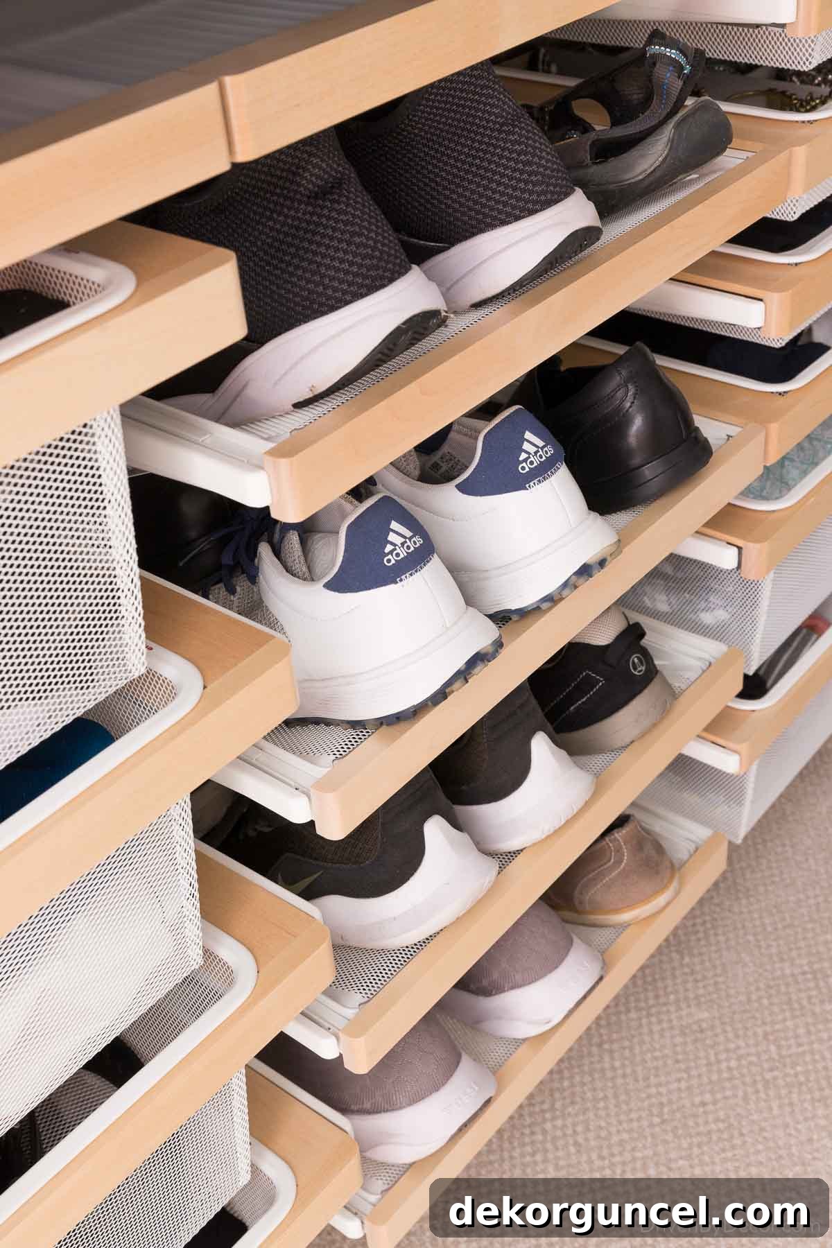 The pull-out shoe racks in our Elfa closet, demonstrating the capacity for both men's and women's footwear.