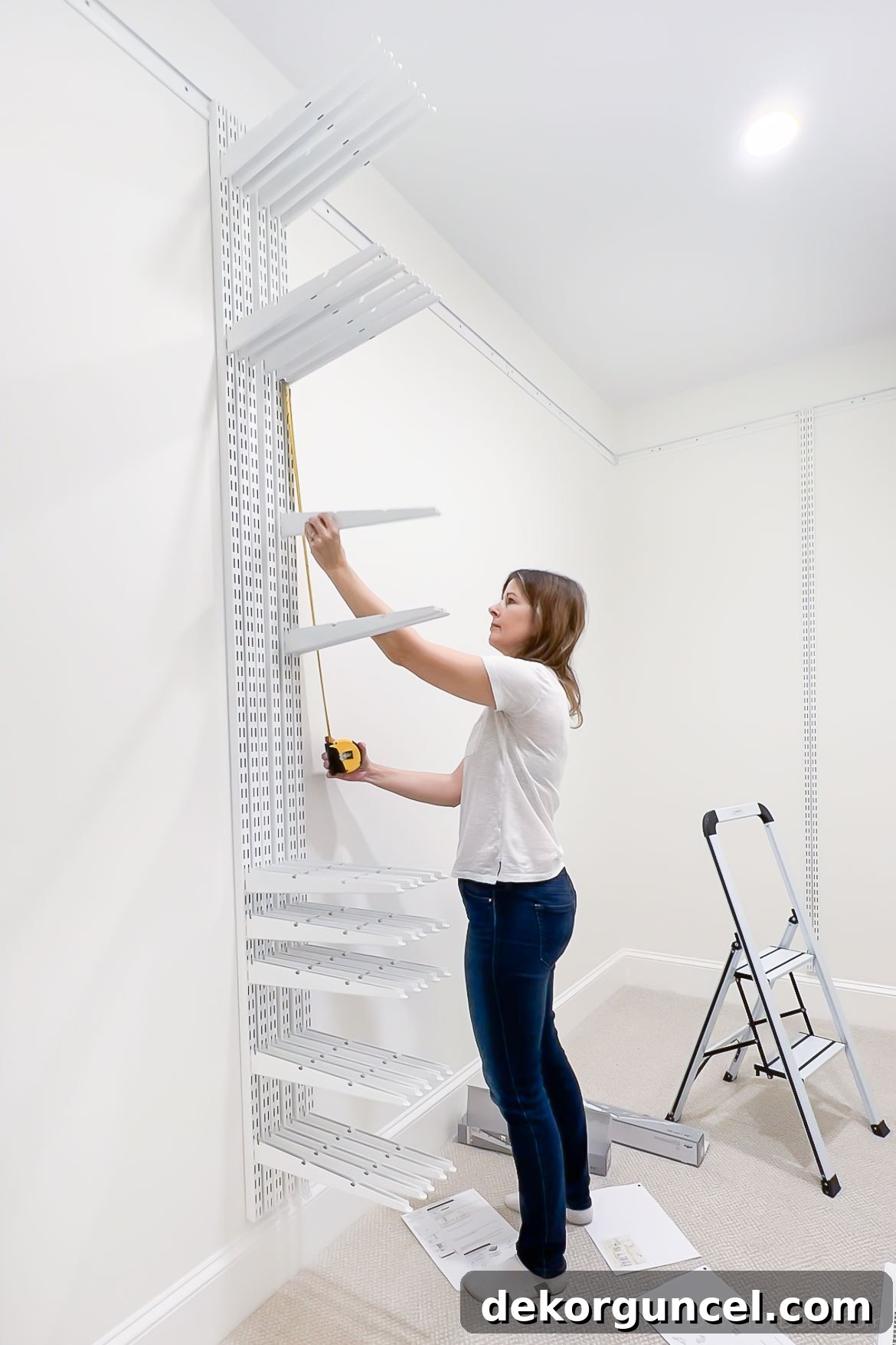 Attaching the supportive brackets to the vertical rails of the Elfa closet system, customizing shelf and drawer positions.