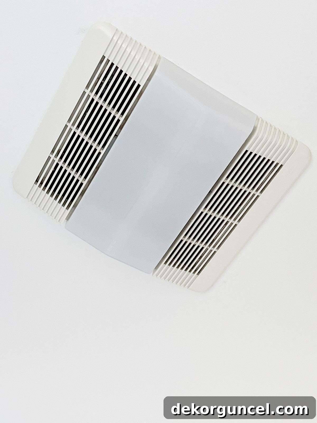 An unappealing, standard builder-grade combination bathroom light and exhaust fan, detracting from bathroom aesthetics.