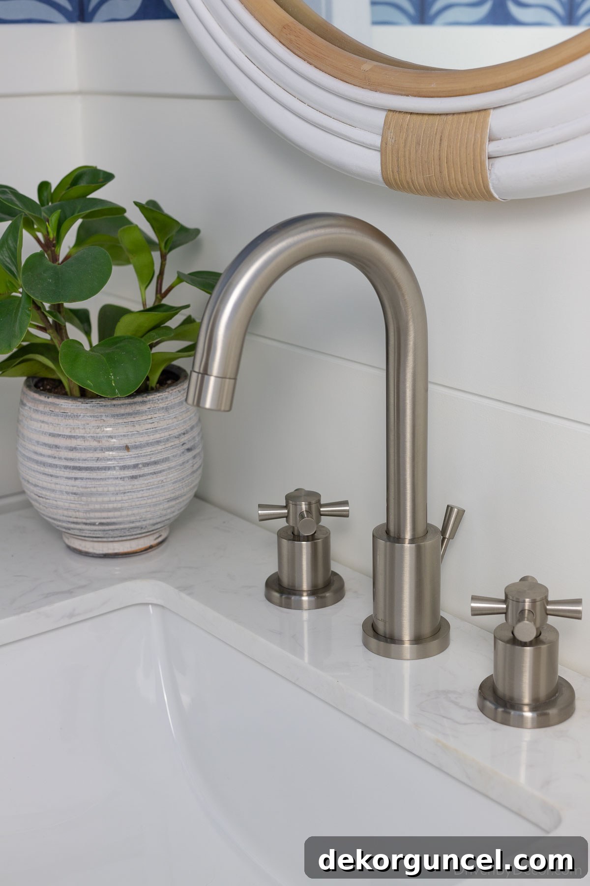 A high-arched bathroom faucet in a brushed nickel finish, beautifully complementing the new vanity in our powder room