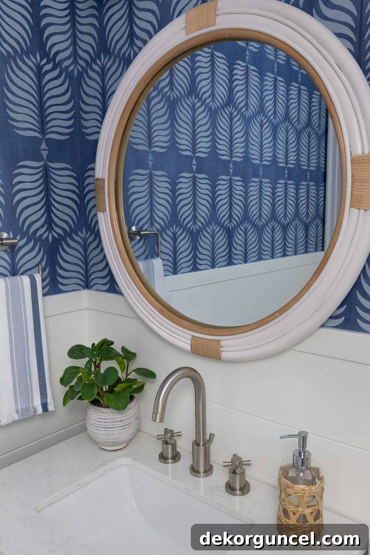 A stylish white round rattan mirror gracefully overlapping the shiplap in our hall bathroom, reflecting natural light and adding texture