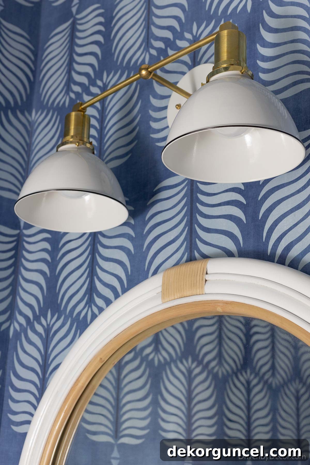 The stunning brass and white double-light sconce illuminating our bathroom mirror and vanity, providing both style and ample light