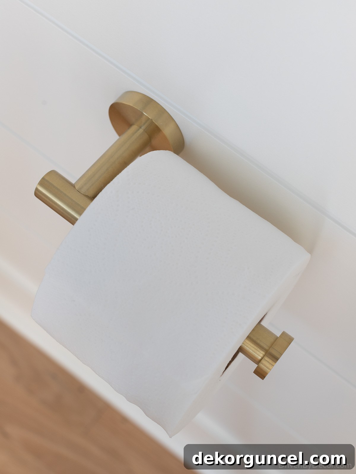 A stylish brushed gold toilet paper holder, offering a chic mixed-metal accent in the bathroom design