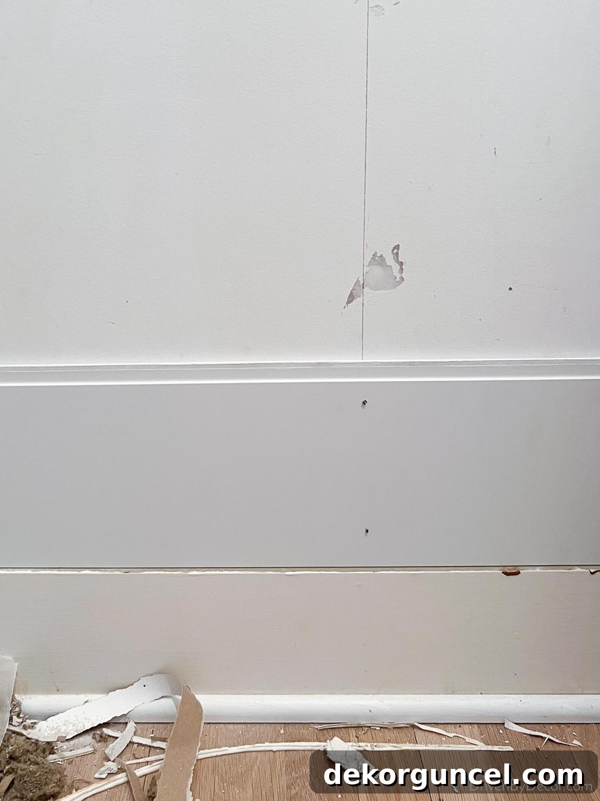 The first row of our bathroom shiplap being installed, perfectly resting on the baseboard and secured into wall studs