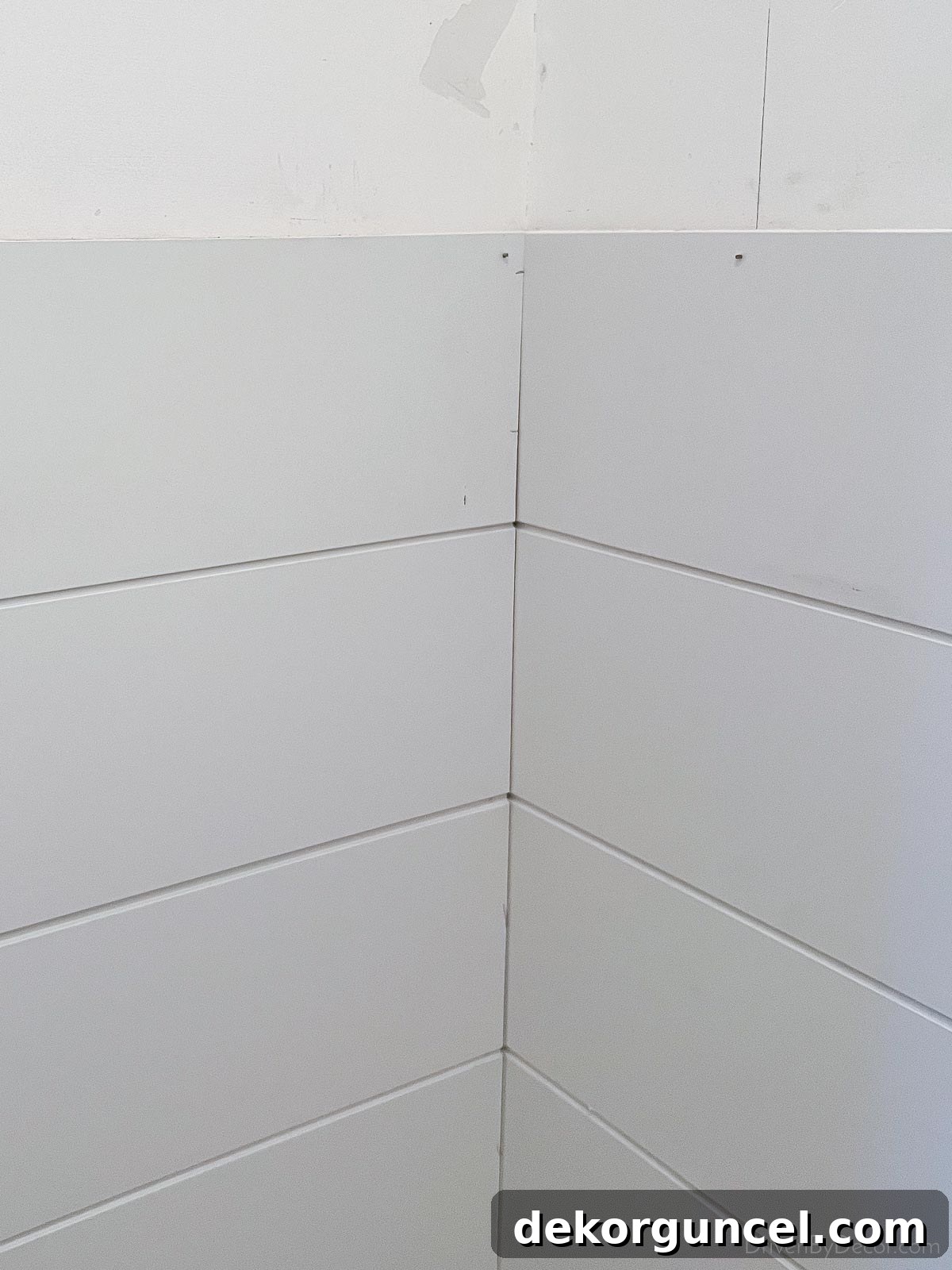 The perfectly finished top row of our bathroom shiplap, showcasing the clean edge after the projecting piece was removed