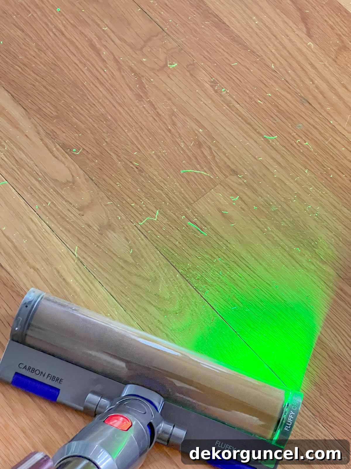 Dyson v15 Detect cordless vacuum with green laser illuminating hidden dirt and dust on a hard floor