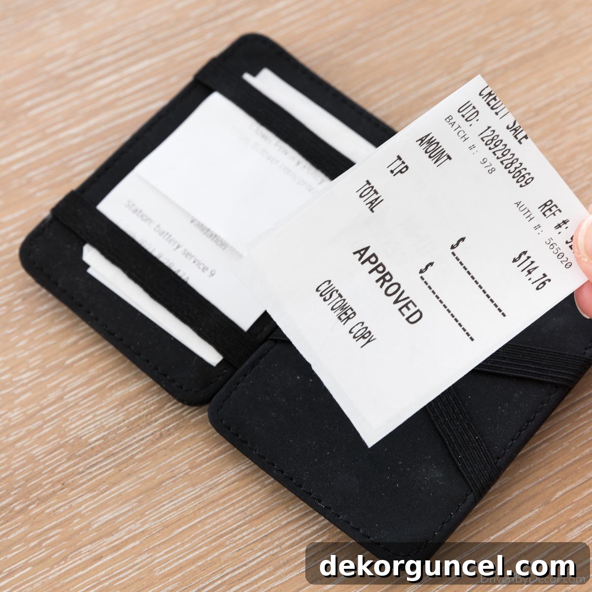 Magic wallet, showing a receipt being placed loosely inside before being secured by elastic bands.