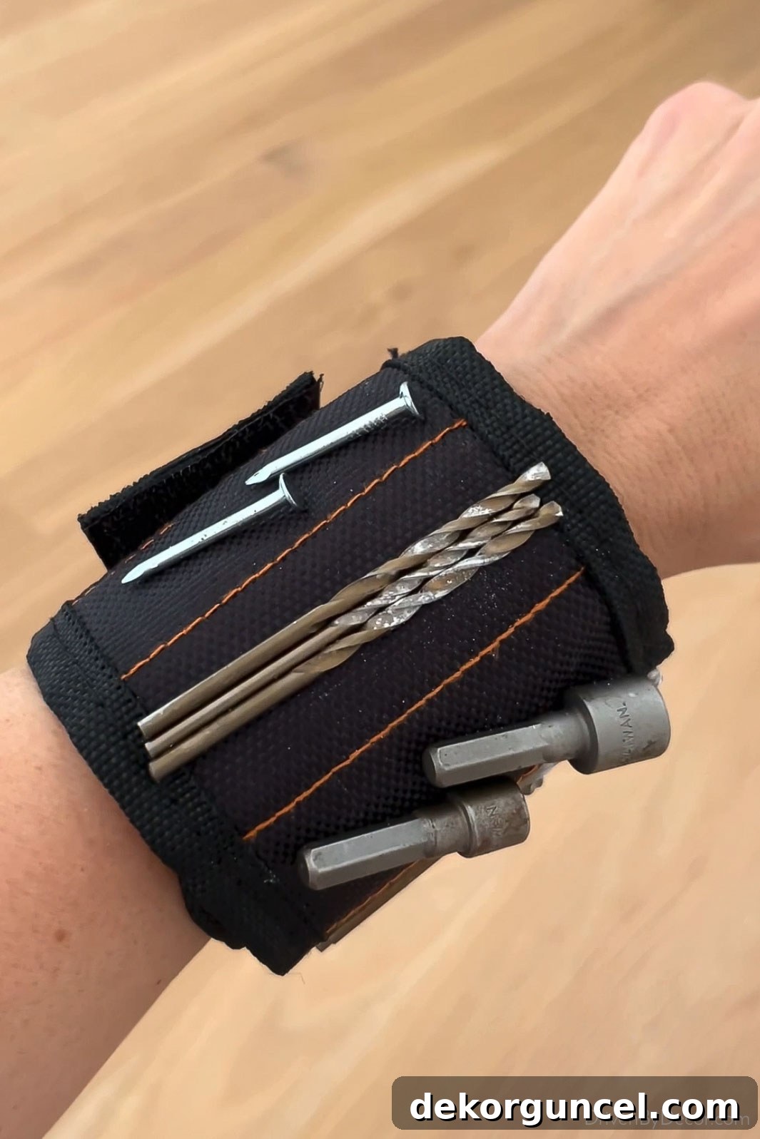 Magnetic wristband securely holding nails, screws, and drill bits, an essential tool for DIY projects and a great Father's Day gift.