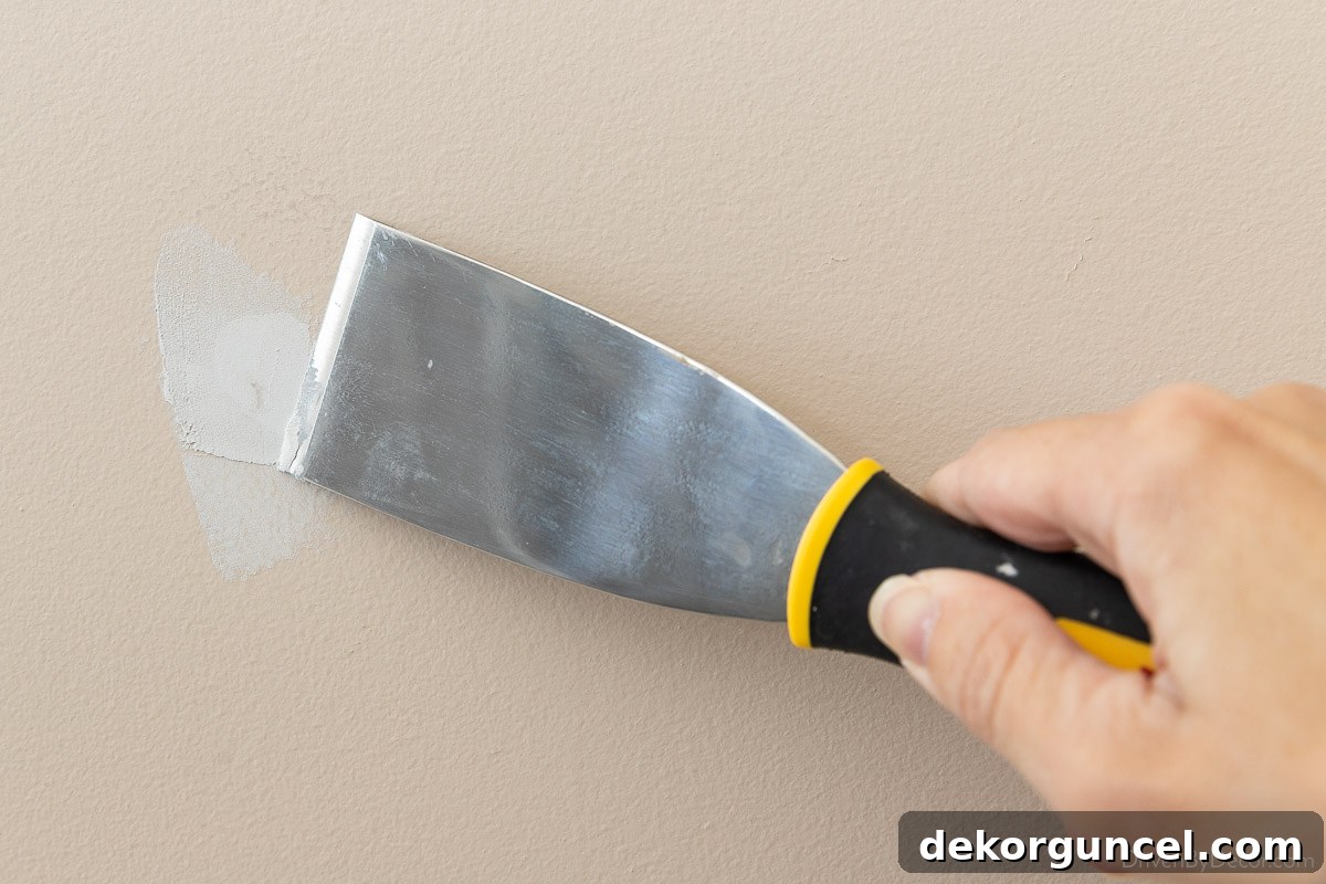 Master Room Painting: 10 Easy Steps for a Perfect Finish 14 Using a putty knife and spackling to fix small hole in the wall