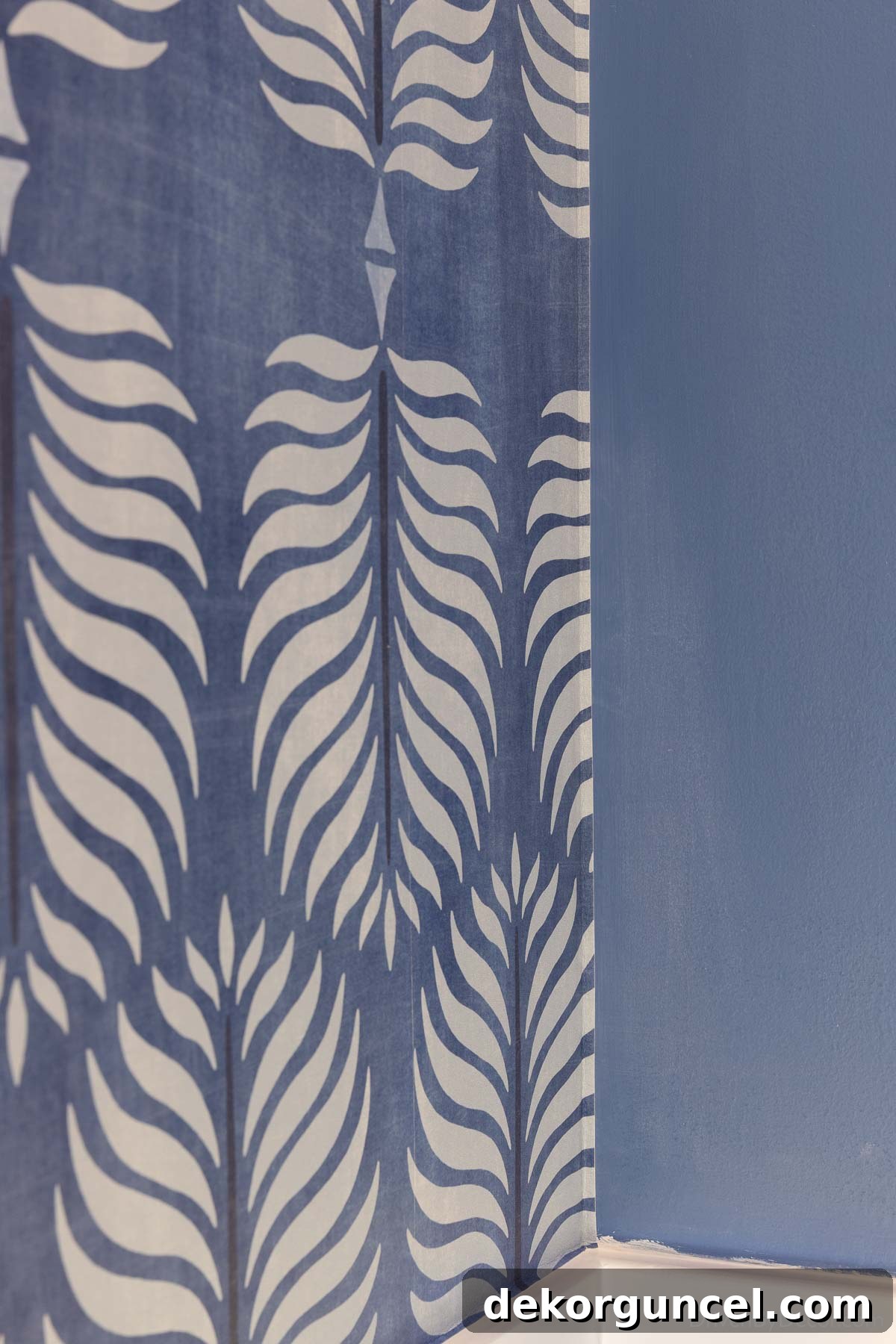 Finished wallpaper installation in a corner, showing the two separate strips neatly overlapping for a clean transition.