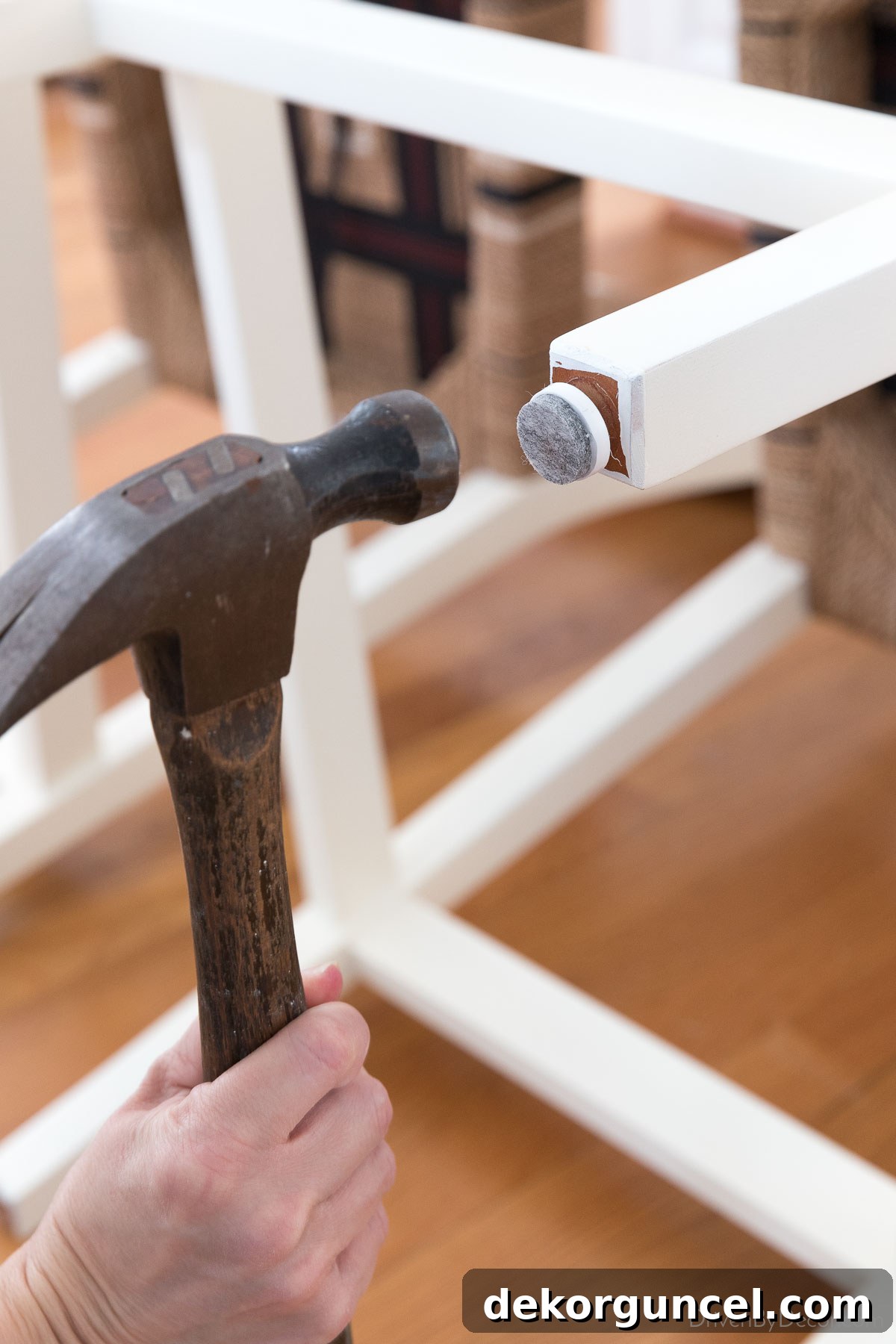 Nailing felt pads onto the feet of chairs to protect hardwood floors