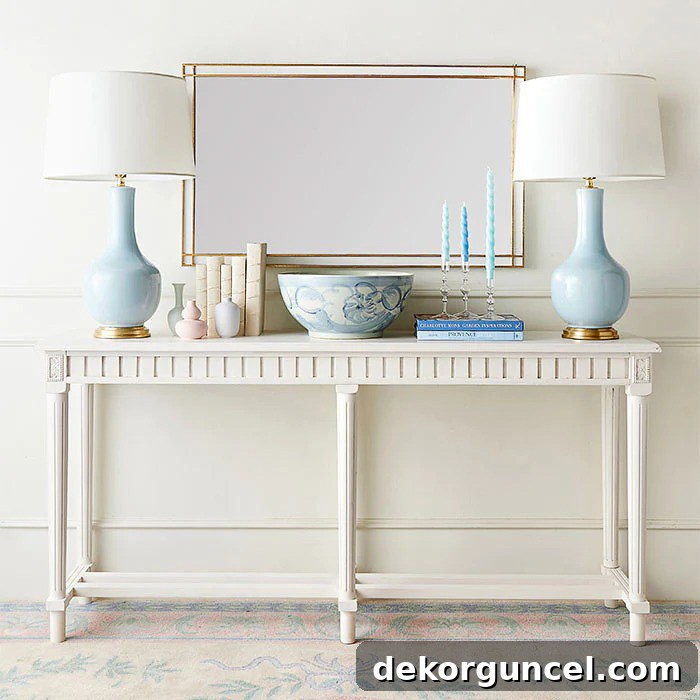 Console table decor featuring stacked books, lamps, and a decorative bowl