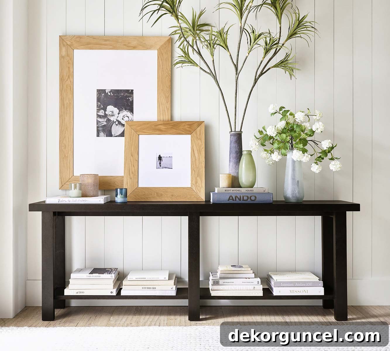 Wood framed art layered on a console table for a coastal vibe