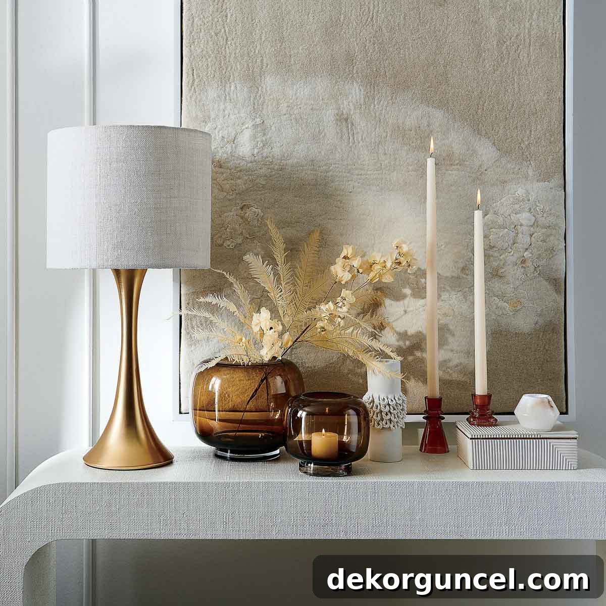 Lamp, candlesticks, art, and decorative boxes as console table decor